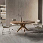 Imagen de la Mesa Roma de melamina con base de madera en forma de cruz y tapa redonda. Abierta con 4 silla marni alrededor